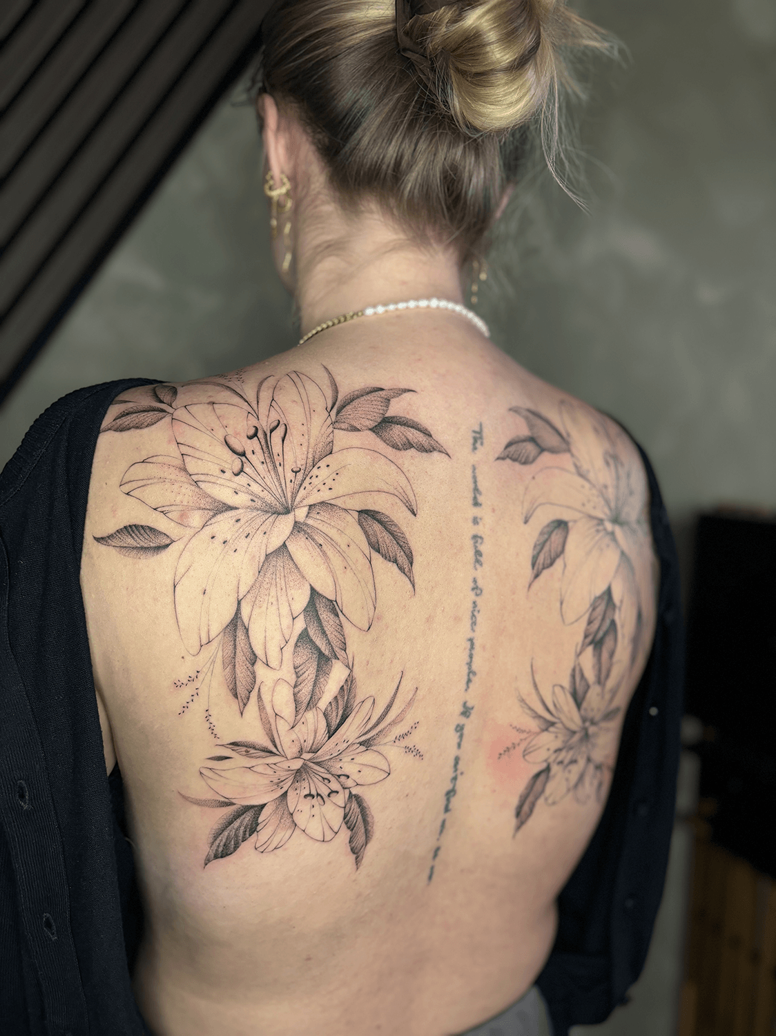Fineline tatovering med liljer på ryg – Timeless Studio Roskilde